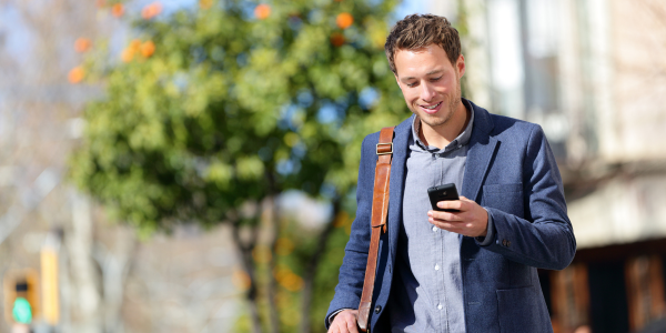 A young man using an online booking system on his mobile